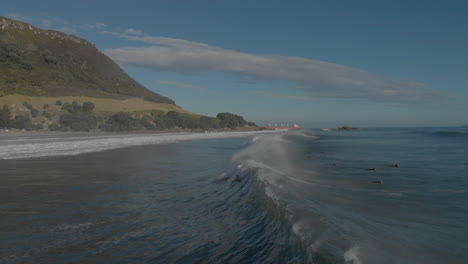 AERIAL:-Surfers-at-mount-Maunganui-Beach,-New-Zealand