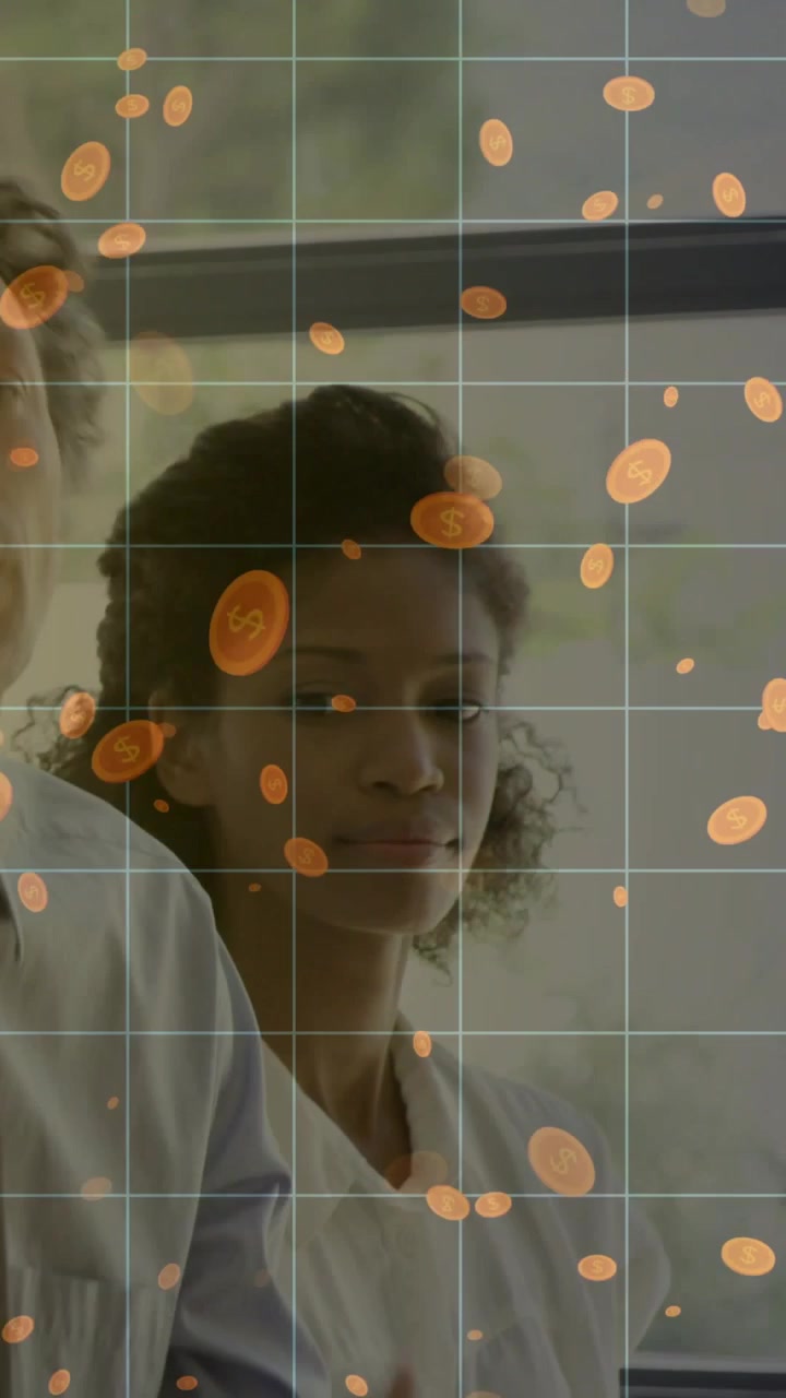 Vertical video: Camera panning window showing 2 women clapping, celebrating amid orange dots in lab