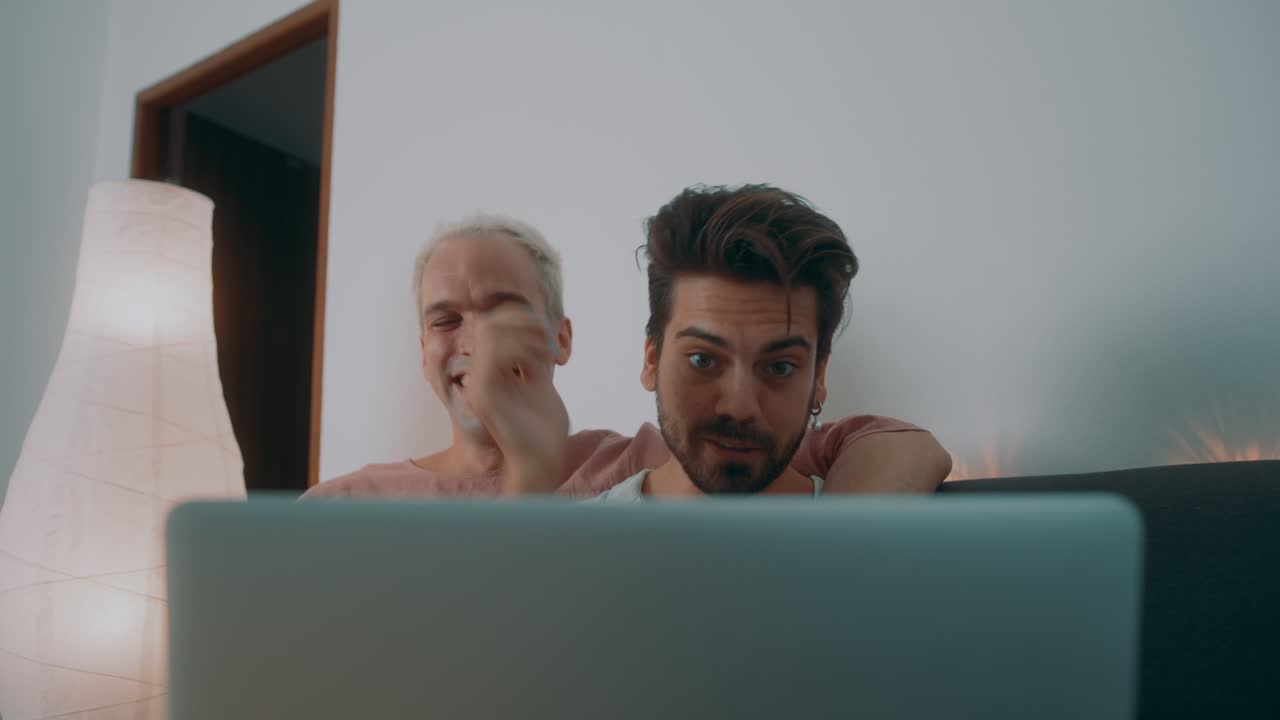 Gay couple watching something on a laptop