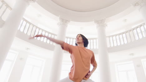 Below-View-Of-A-Focused-Young-Man-In-Casual-Wear-Performing-A-Contemporary-Dance-In-The-Studio