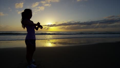 mujer china sana en ropa deportiva por el amanecer del océano