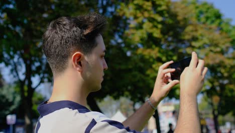 primer plano de un joven tomando fotos con un teléfono móvil