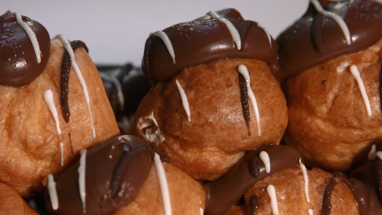 tiro de panado lento de profiteroles pastel choux con relleno de crema batida y cubierta de chocolate