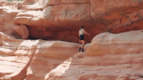 Junge-Kaukasische-Frau,-Die-Auf-Felsen-Im-Paradise-Valley,-Agadir,-Marokko,-Spaziert