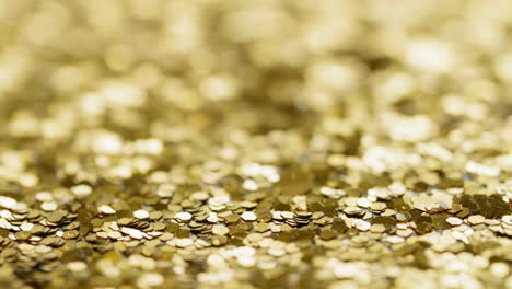 Shallow-focus-of-gold-sequins,-tilt-down