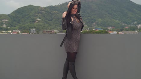 on a rooftop with a view of the lively city of port of spain, trinidad, a woman is enjoying herself with the skyline in the background