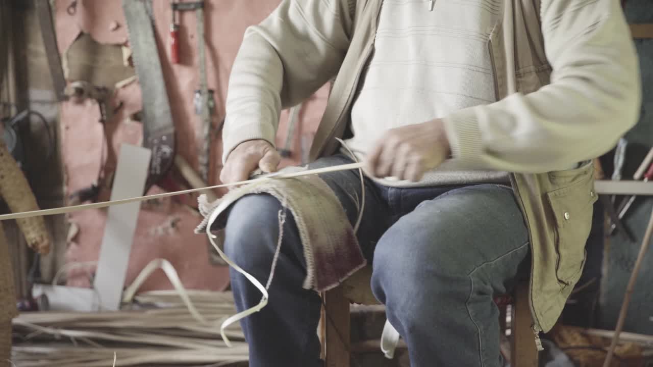 Basket weaving master shapes wooden sticks. 4K footage. Craft concept.