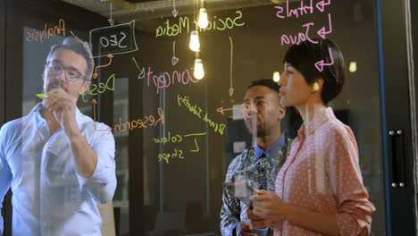 ejecutivos de negocios discutiendo sobre la pared de vidrio en la oficina 4k