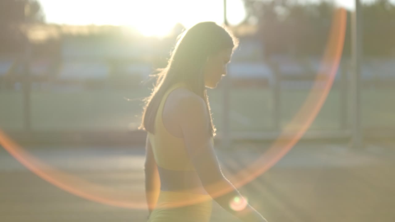 женщина, идущая по рельсам при заходе солнца.