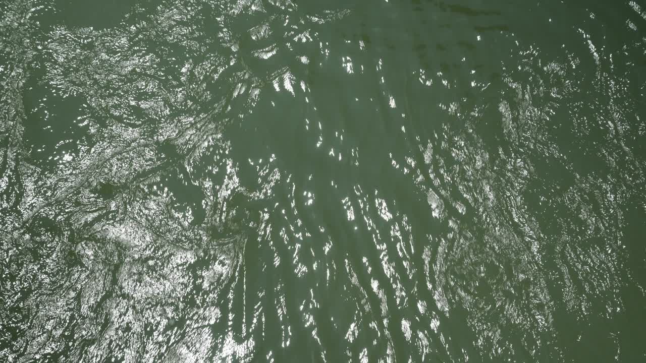 Up close macro video of water flowing and the suns reflection off of it.