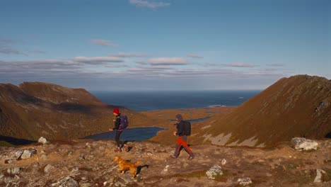 Hikers with a dog on mountain trail in Måtinden, scenic outdoor adventure