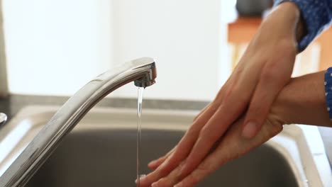 Caucasian-woman-washing-her-hands-with-soap-at-home