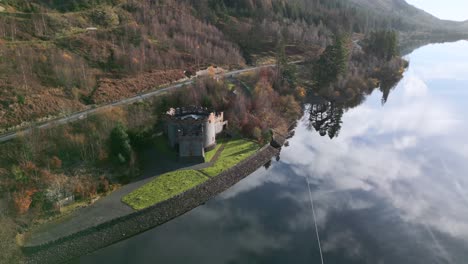 cloud reflections on still water with lakeside road traffic and stone tower construction