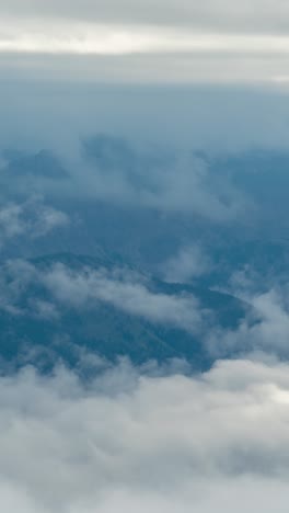 vertical 4k timelapse, clouds and dense fog inversions above valley and high mountain peaks