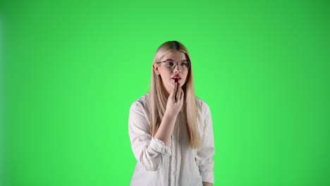 woman with white shirt and glasses puts on red lipstick, green background