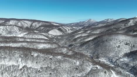 Aerial-establishing-shot-of-Japan-snowy-valley-near-the-Nagano-Myoko-Yamanochi-region