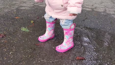 Cerca-De-Una-Niña-Con-Botas-De-Goma-Rosa-Saltando-En-Un-Pequeño-Charco