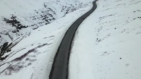 Vista-Aérea-De-Los-Automóviles-Que-Circulan-Por-Una-Carretera-En-Las-Montañas-Islandesas