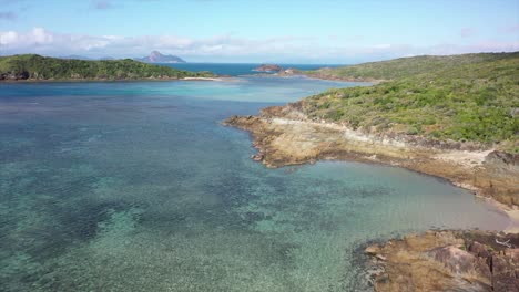 pacific aerial over shallow vivid green coral lagoon in qld australia