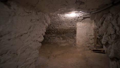 Toma-En-Movimiento-En-Una-Antigua-Bodega-De-Vino-De-Piedra-Vacía-En-Una-Antigua-Casa-Francesa-Fría