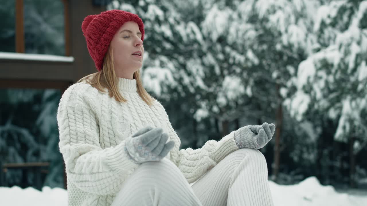 백인 여성이 겨울에 야외에서 명상하고 있습니다.