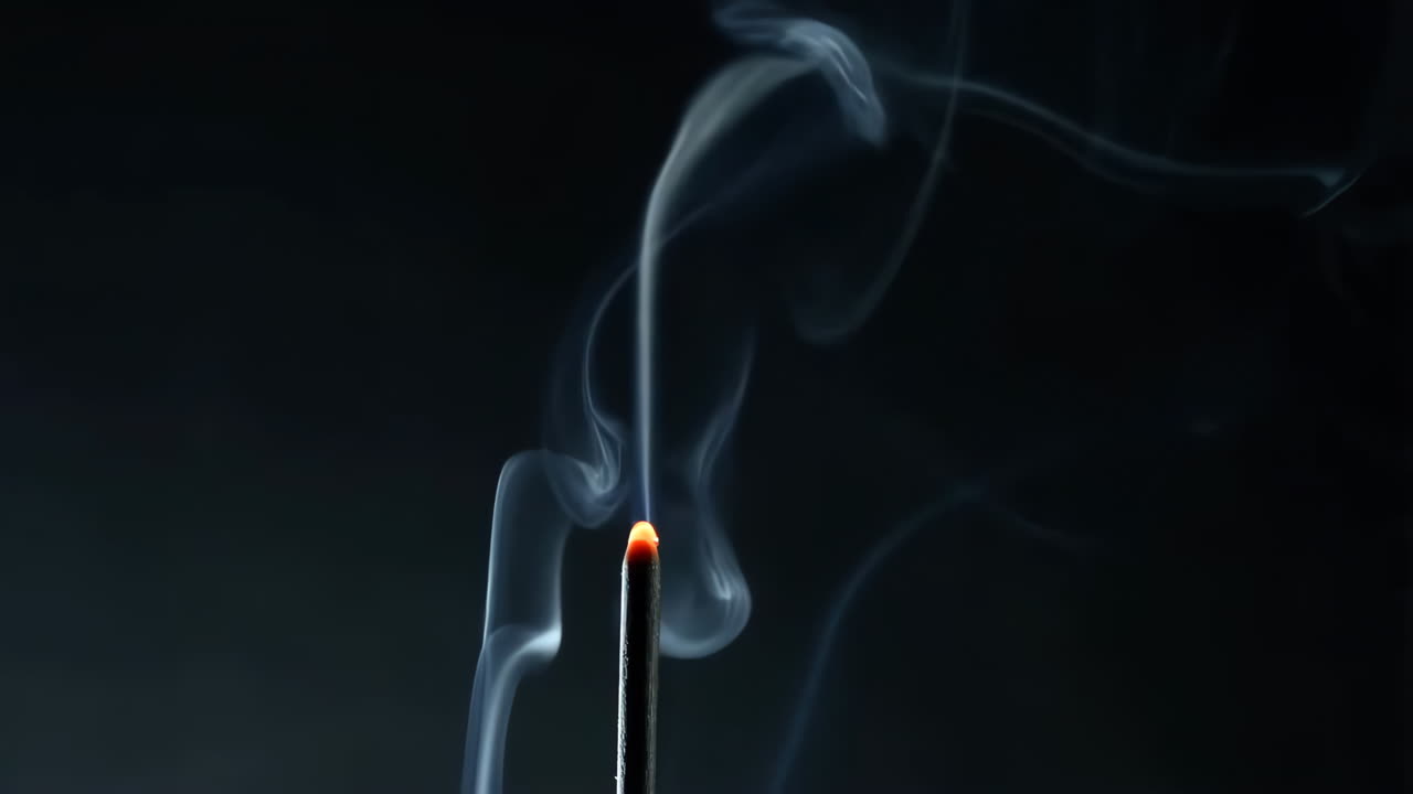 Incense Stick Burning with Elegant Smoke against Dark Background