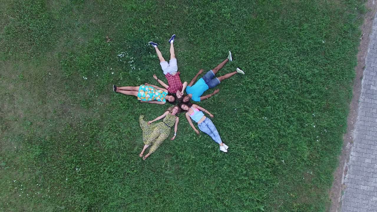 잔디에 누워있는 별 모양을 형성하는 친구 그룹의 안테나