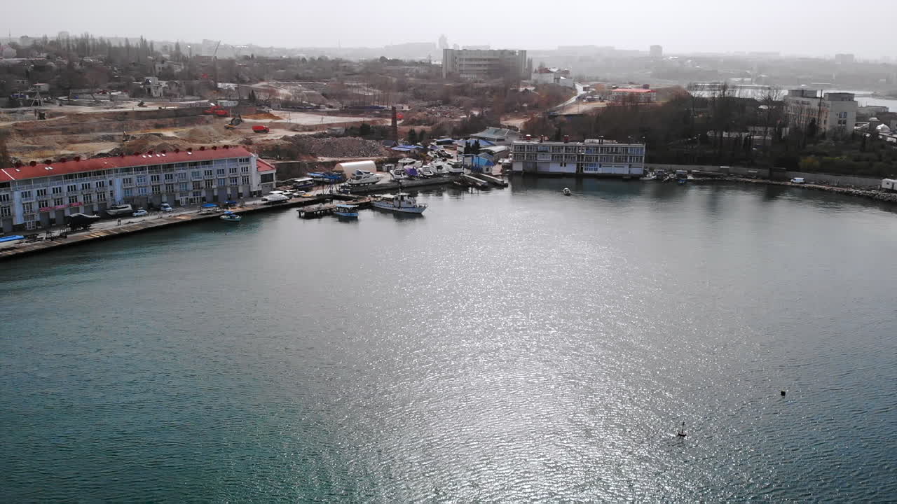 Aerial view of a harbor with boats and city skyline