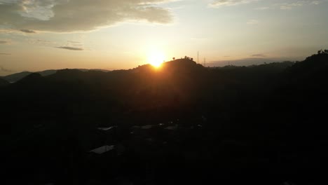 Sunset-coming-up-over-the-mountains-casting-a-silhouette-in-Lombok,-Indonesia