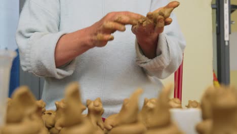 Close-up-of-hands-handcrafting-clay-animal-figures-in-Thanh-Ha,-Vietnam,-a-traditional-pottery-village-famous-for-tourism-and-souvenir-production