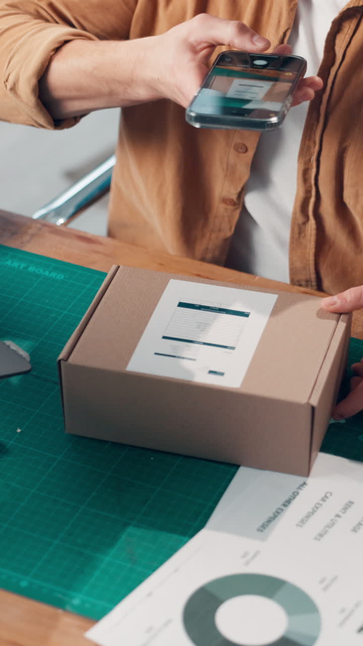 Person Scanning Shipping Label on Cardboard Box with Smartphone