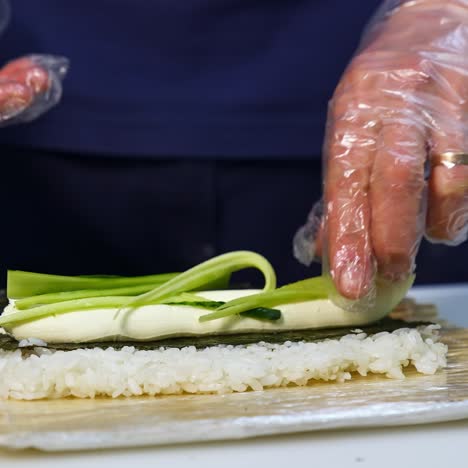 hands cooking sushi with rice