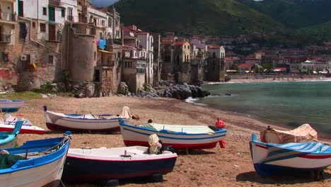 boats on a beach next to the ocean and houses in cefalu italy   2