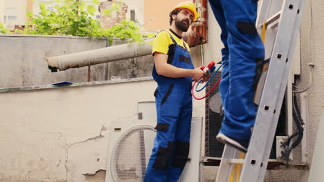 mechanic and colleague fix condenser