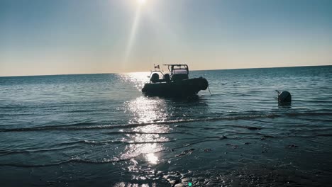 Shot-of-a-Boat-in-the-pleasant-ocean-in-France,-reflection-of-the-sun-shining-on-the-water-waves