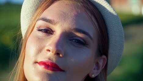 stunning hd footage of a beautiful young white caucasian woman with a knitted hat and red lipstick looks into the camera, smiling and posing