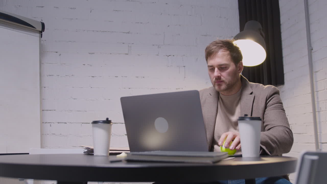 Serious Businessman Using Laptop Computer While Sitting At Table In The Boardroom