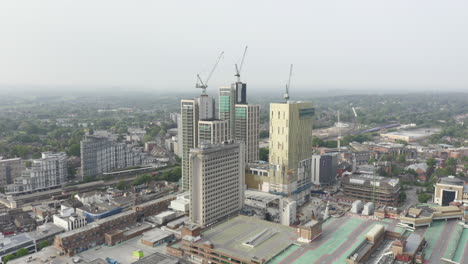 Drone-Aerial-shot-of-Woking-Cityscape-a-town-in-England-with-high-rise-skyscrapers-and-cranes-building-works-with-drone-tracking-zooming-in