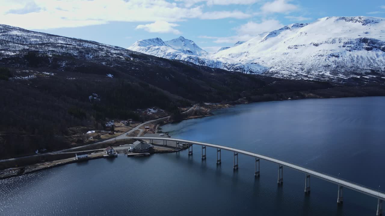 impresionante vista aérea de las montañas nevadas y el pueblo junto al fiordo y el puente de gratangen en noruega
