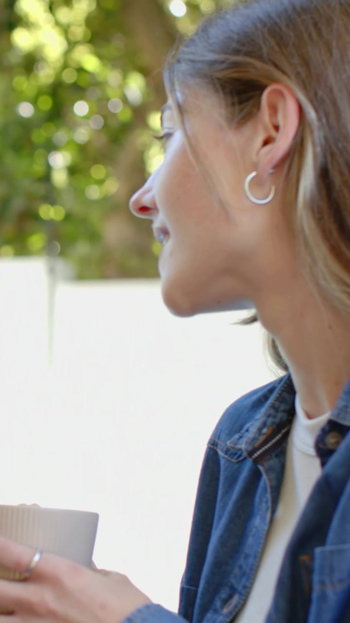 Video verticale: Dopo una voce fuori campo, donna in giacca di jeans che parla a casa, con una tazza, spazio per il testo