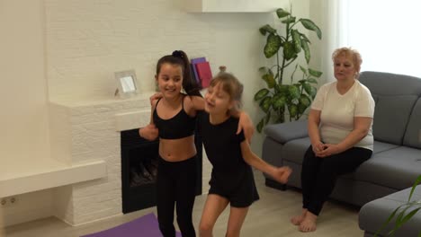 two happy little girls are dancing and smiling while playing in children's room at home