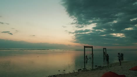 Timelapse-Del-Atardecer-En-Gili-Trawangan,-Indonesia,-Con-El-Sol-Cayendo-A-Través-De-Columpios-En-El-Mar