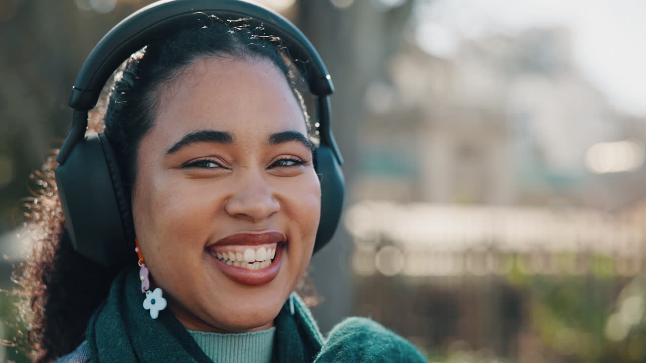 Woman with Headphones and Flower Earrings Smiling Outdoors