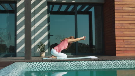 businesswoman doing yoga near pool. relaxed female making child pose.