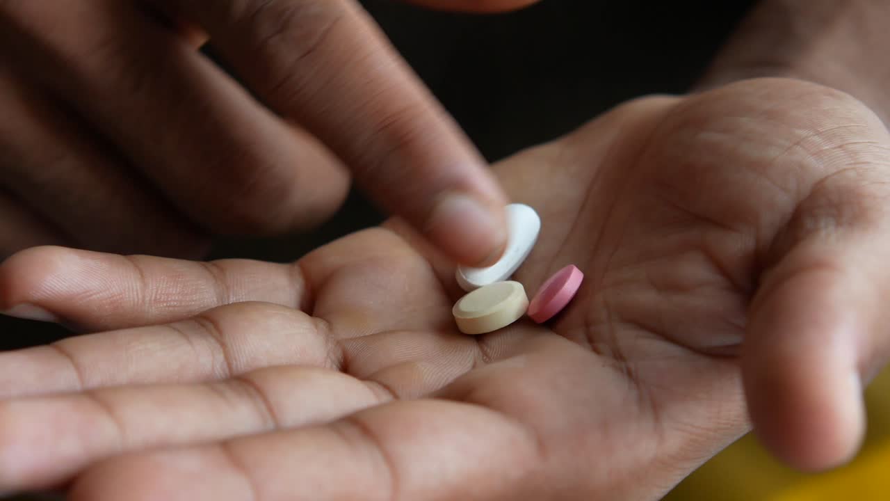 manos que sostienen varias pastillas