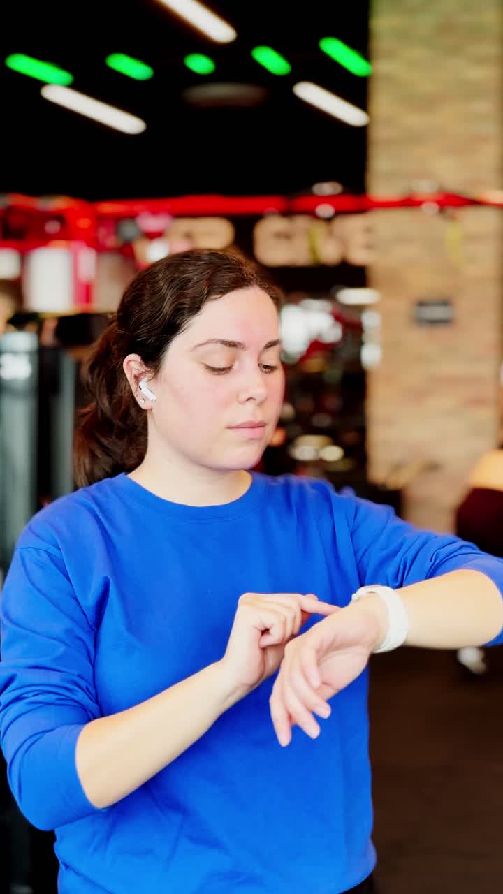 Woman checking smartwatch during gym workout