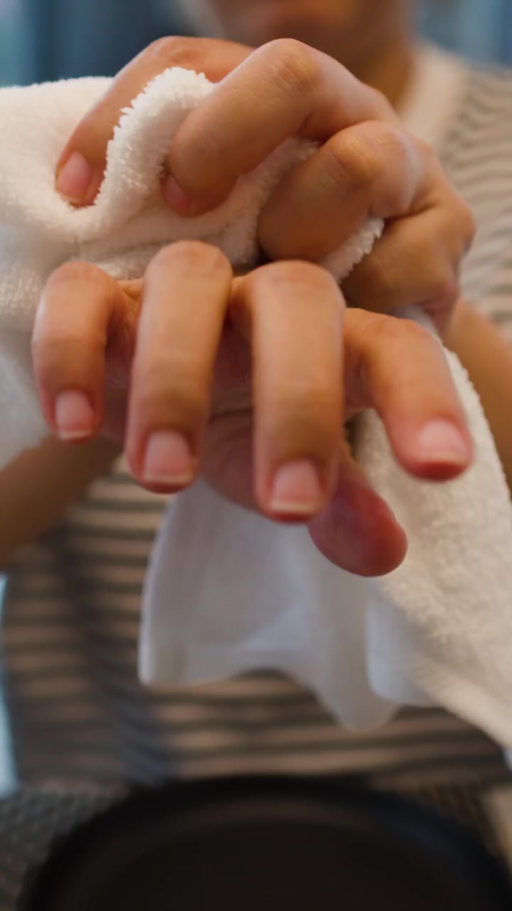 Primo piano di mani che si asciugano con un asciugamano bianco