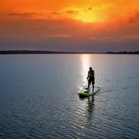 athletic man standing with paddle. surfer floating sup board on vacation