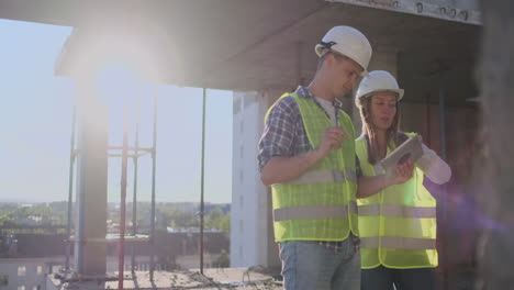 Construction-site-Team-or-architect-and-builder-or-worker-with-helmets-discuss-on-a-scaffold-construction-plan-or-blueprint-or-checklist