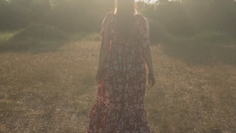 Eine-Zeitlupenaufnahme-Des-Rückens-Einer-Kaukasischen-Frau-In-Einem-Geblümten-Kleid,-Die-Sich-Frei-Fühlt-Und-An-Einem-Schönen-Tag-Im-Freien-In-Indien-Durch-Ein-Feld-Zum-Morgendlichen-Sonnenaufgang-Läuft